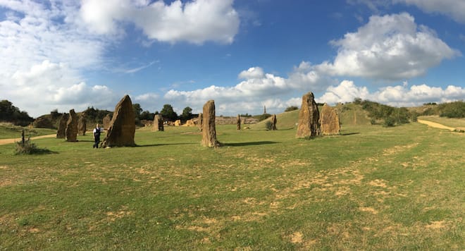 Landscape photo of Ham Hill Stone Circle with Andy leaning on one of the rocks.