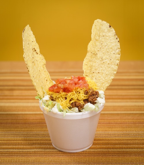 A short cup with Tex-Mex toppings on top and two chips pointing out like cat ears on top.