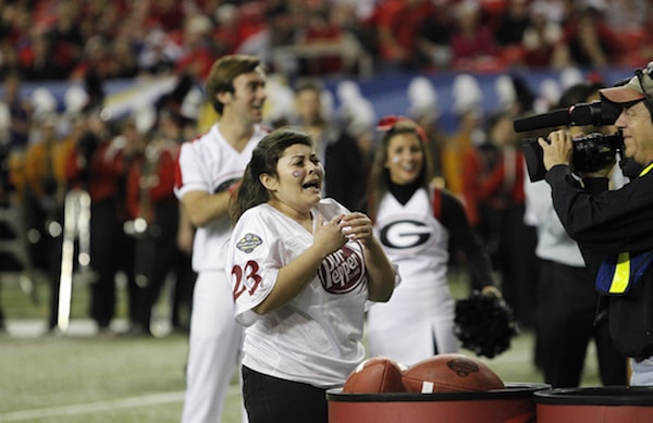 Padilla-Rodríguez emotionally cries out with cameras pointed at her as she receives news on the football field.