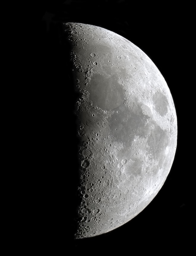 An extreme close up of the moon. Half is in light, half is in darkness.