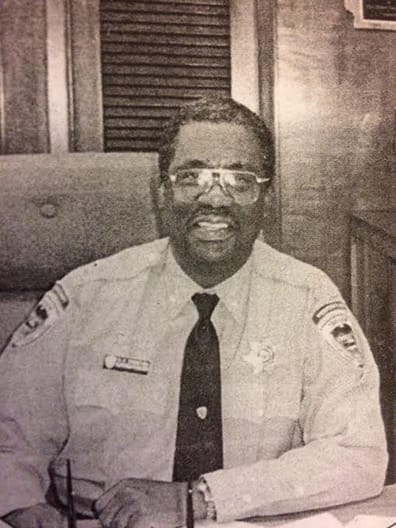 Frank Thompson in a guard uniform at a desk