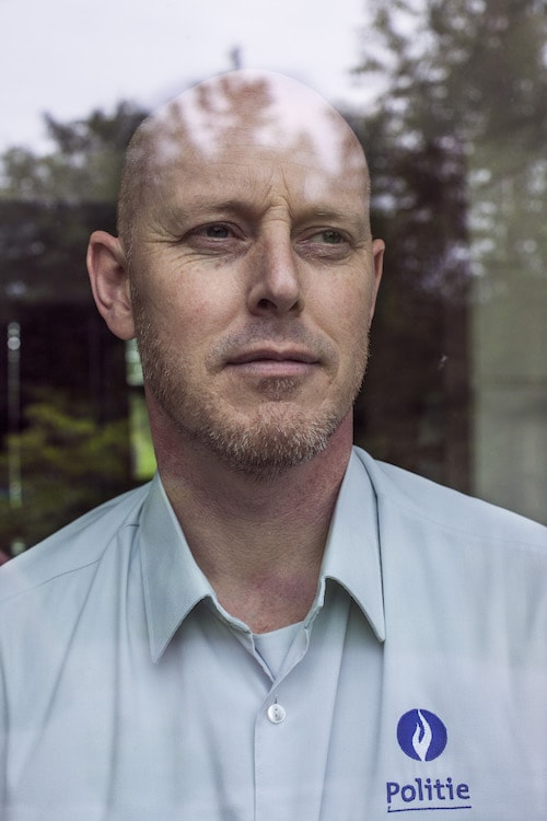 Peter wears a blue collar shirt with the word Police in Belgian.