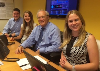Four interns, Paul and three younger interns, at a conference table.