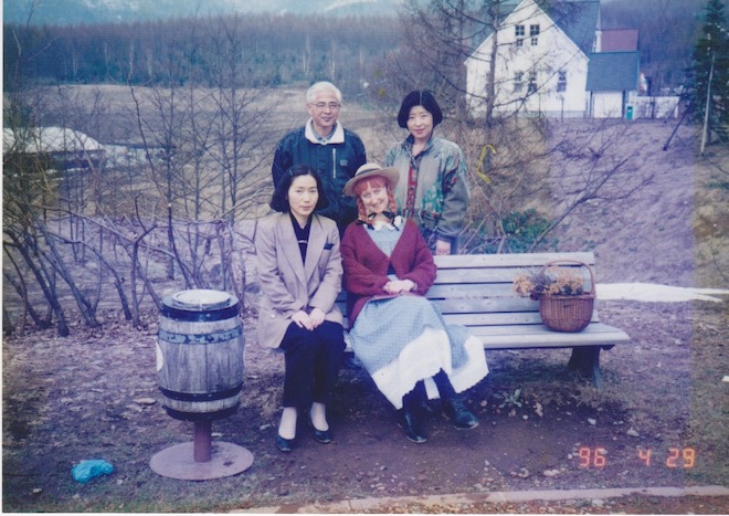 Erin poses with a family with a green building in the background.